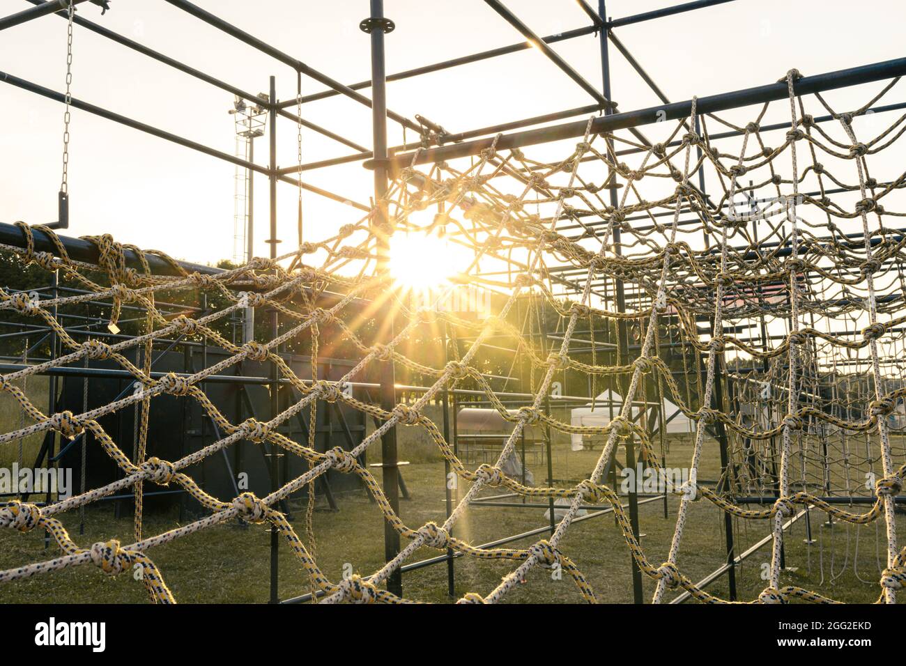obstacle course races climbing rope net with sunset sky Stock Photo