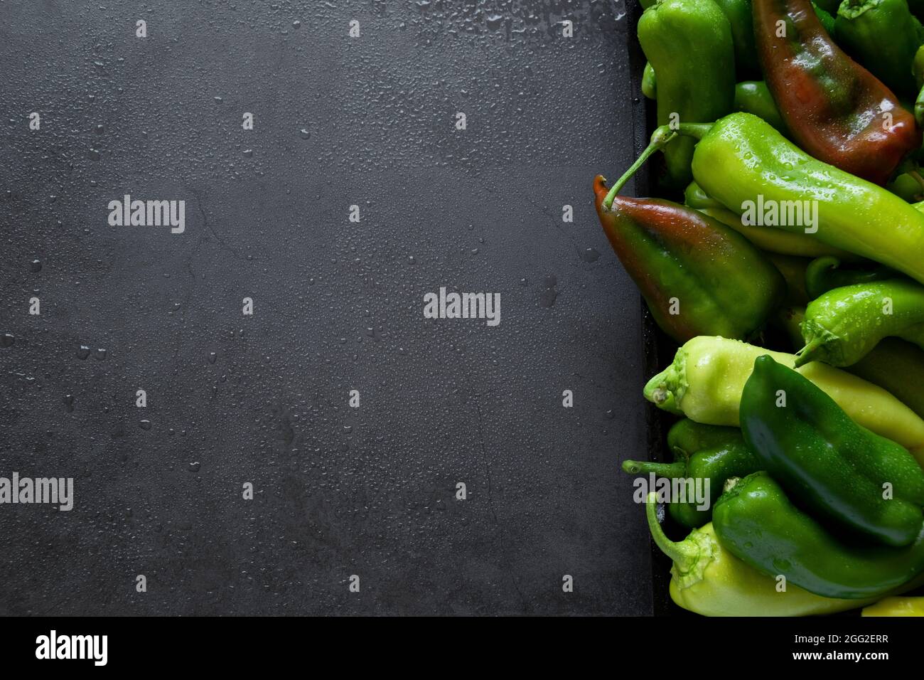 Raw peppers on dark background, food backdrop. Vegetable nutrition ingredients Stock Photo