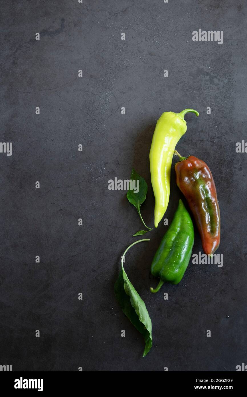 Raw peppers on dark background, food backdrop. Vegetable nutrition ingredients Stock Photo