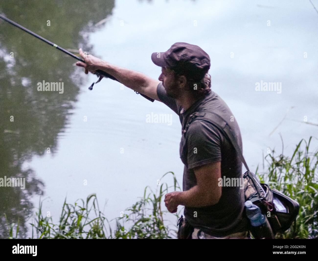 Shallow focus of an Italian man casting a fishing rod on a calm lake Stock  Photo - Alamy