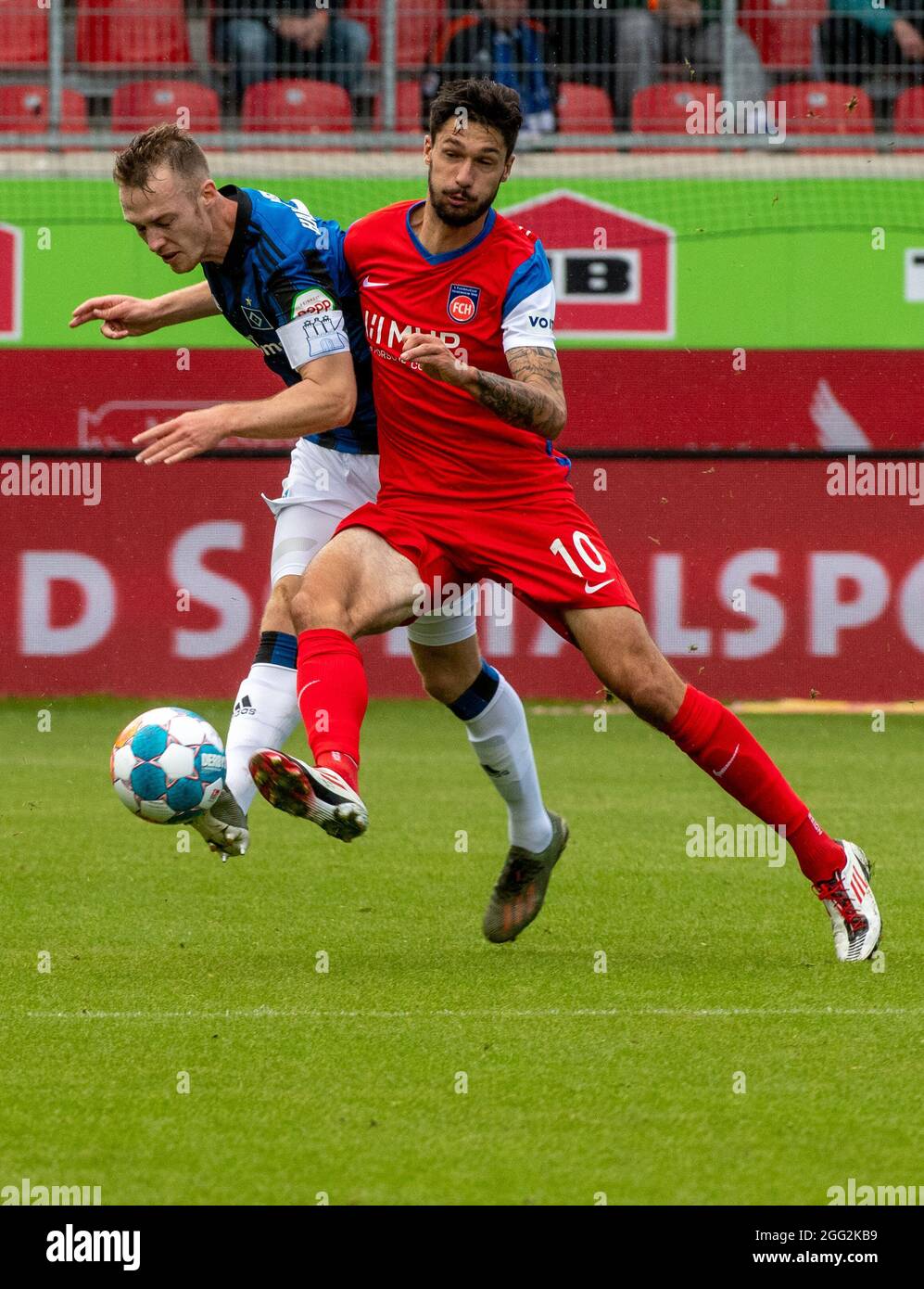 Heidenheim, Germany. 26th Aug, 2021. Football: 2. Bundesliga, 1. FC Heidenheim - Hamburger SV, Matchday 5 at Voith-Arena. Heidenheim's Tim Kleindienst (r) and Hamburg's Sebastian Schonlau fight for the ball. Credit: Stefan Puchner/dpa - IMPORTANT NOTE: In accordance with the regulations of the DFL Deutsche Fußball Liga and/or the DFB Deutscher Fußball-Bund, it is prohibited to use or have used photographs taken in the stadium and/or of the match in the form of sequence pictures and/or video-like photo series./dpa/Alamy Live News Stock Photo