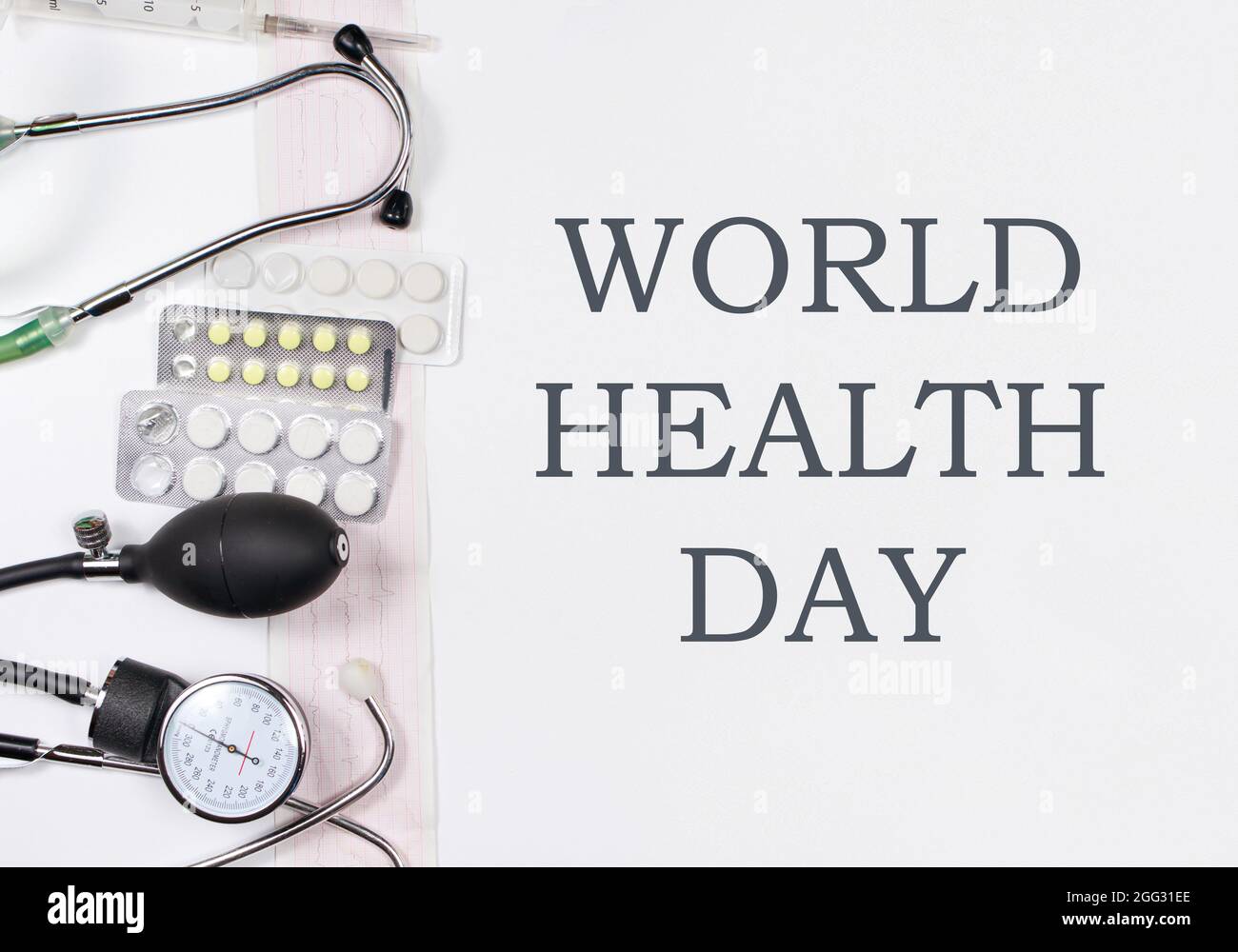 Medical instruments tonometer, phonendoscope, ECG and medicine with text World Health Day Stock Photo