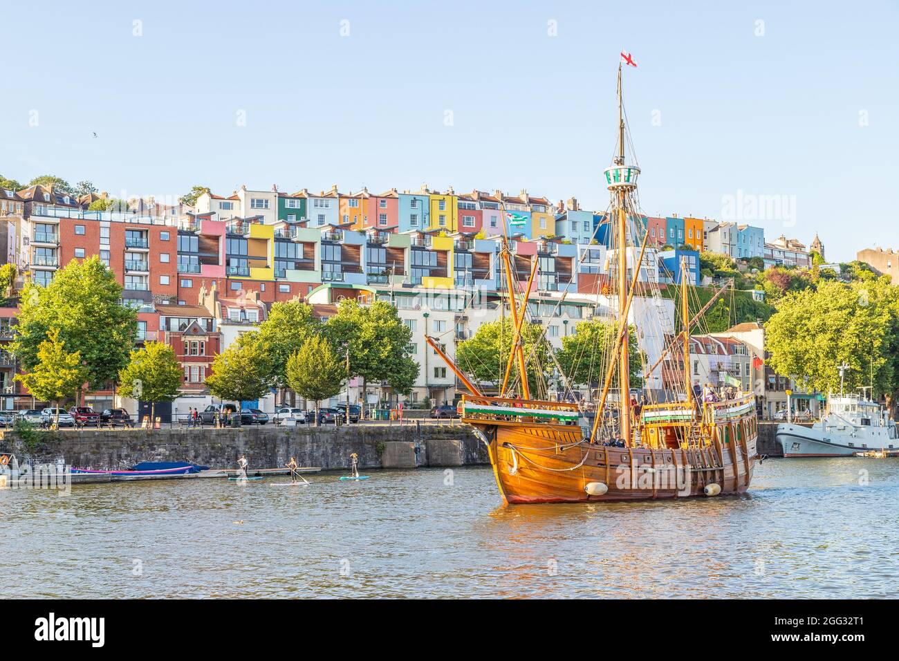 BRISTOL, UK - 18TH AUG 2021: A large boat and colourful buildings and boats along the Bristol Waterfront. Some people can be seen. Stock Photo