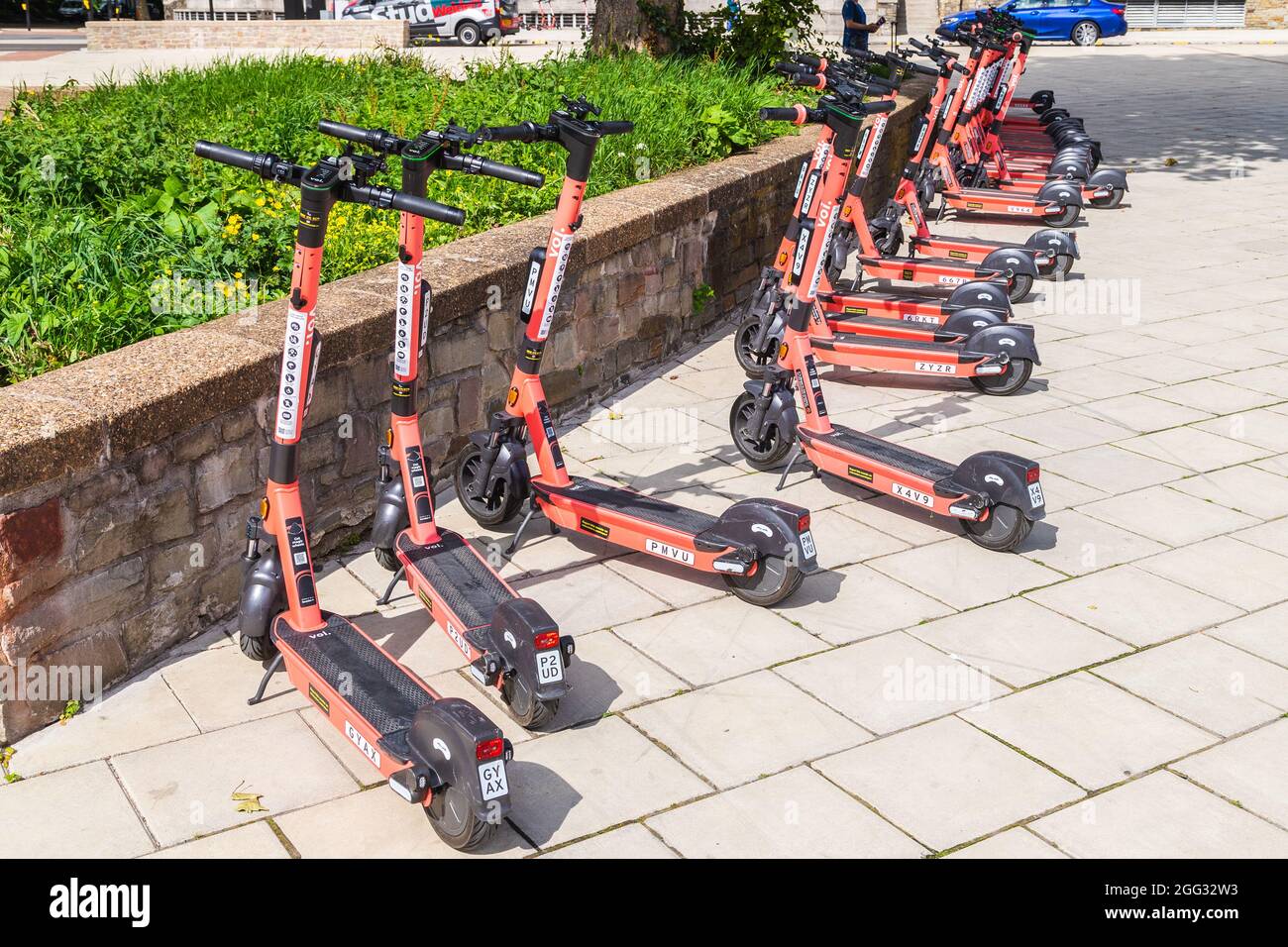 BRISTOL, UK - 19TH AUG 2021: Voi. electric scooters on a street in Bristol during the day. A person can be seen in the background. Stock Photo