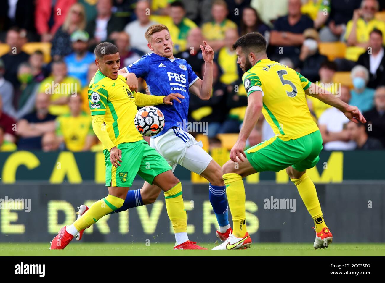 Carrow Road, Norwich, Norfolk, UK. 28th Aug, 2021. Premier League football, Norwich versus Leicester; Harvey Barnes of Leicester City competes for the ball with Max Aaron and Grant Hanley of Norwich City Credit: Action Plus Sports/Alamy Live News Stock Photo