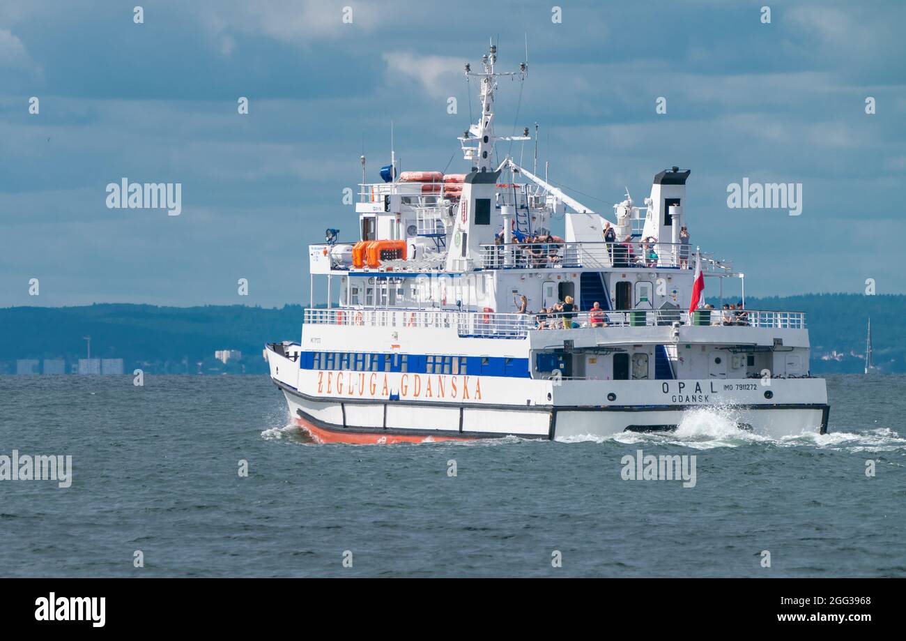Hel, Poland - 08.01.2021: A passenger boat with people onboard on its way across Baltic sea from Hel to Gdansk on a hazy warm summer day. Summer Stock Photo