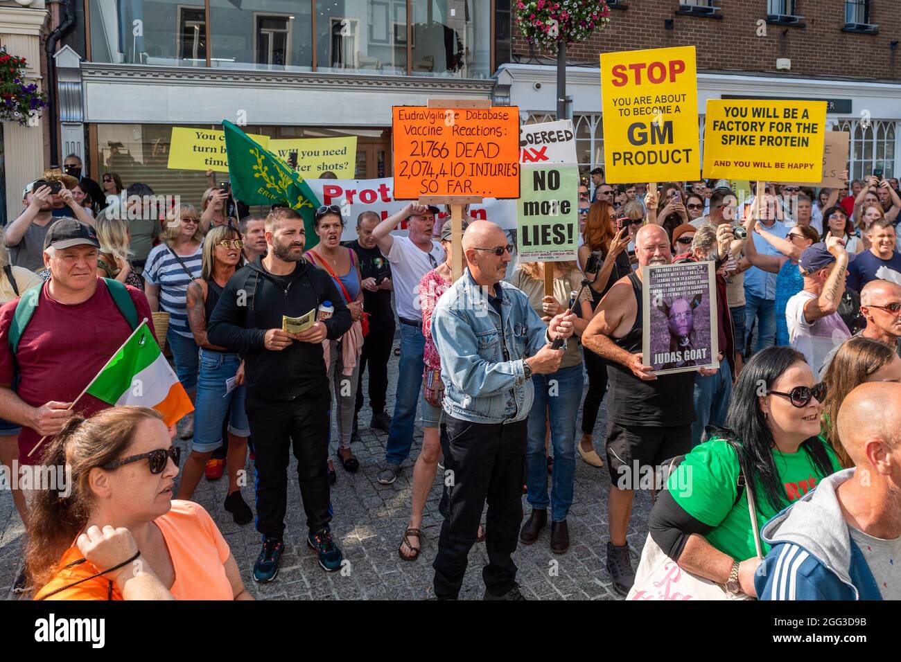 Waterford, Ireland. 28th Aug, 2021. Around 200 people gathered this afternoon in Waterford city centre to protest against the COVID-19 vaccines, which they say are experimental and still on trial. The protestors gathered at the clock tower on Meagher's Quay and marched through the city centre. The protestors stopped outside Mulligan's Pharmacy, which is offering the COVID-19 vaccine, and chanted 'Shame on you'. Two Gardai stood in the doorway of the pharmacy. Credit: AG News/Alamy Live News Stock Photo