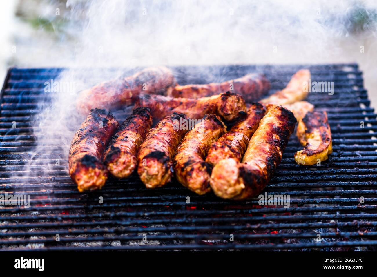 Grilling sausages on barbecue grill. Delicious sausages on charcoal
