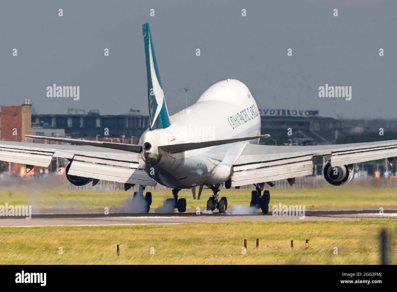 Cathay Pacific Cargo Boeing 747 freighter Jumbo Jet airliner jet plane landing at London Heathrow Airport, UK, touching down with tyre smoke Stock Photo