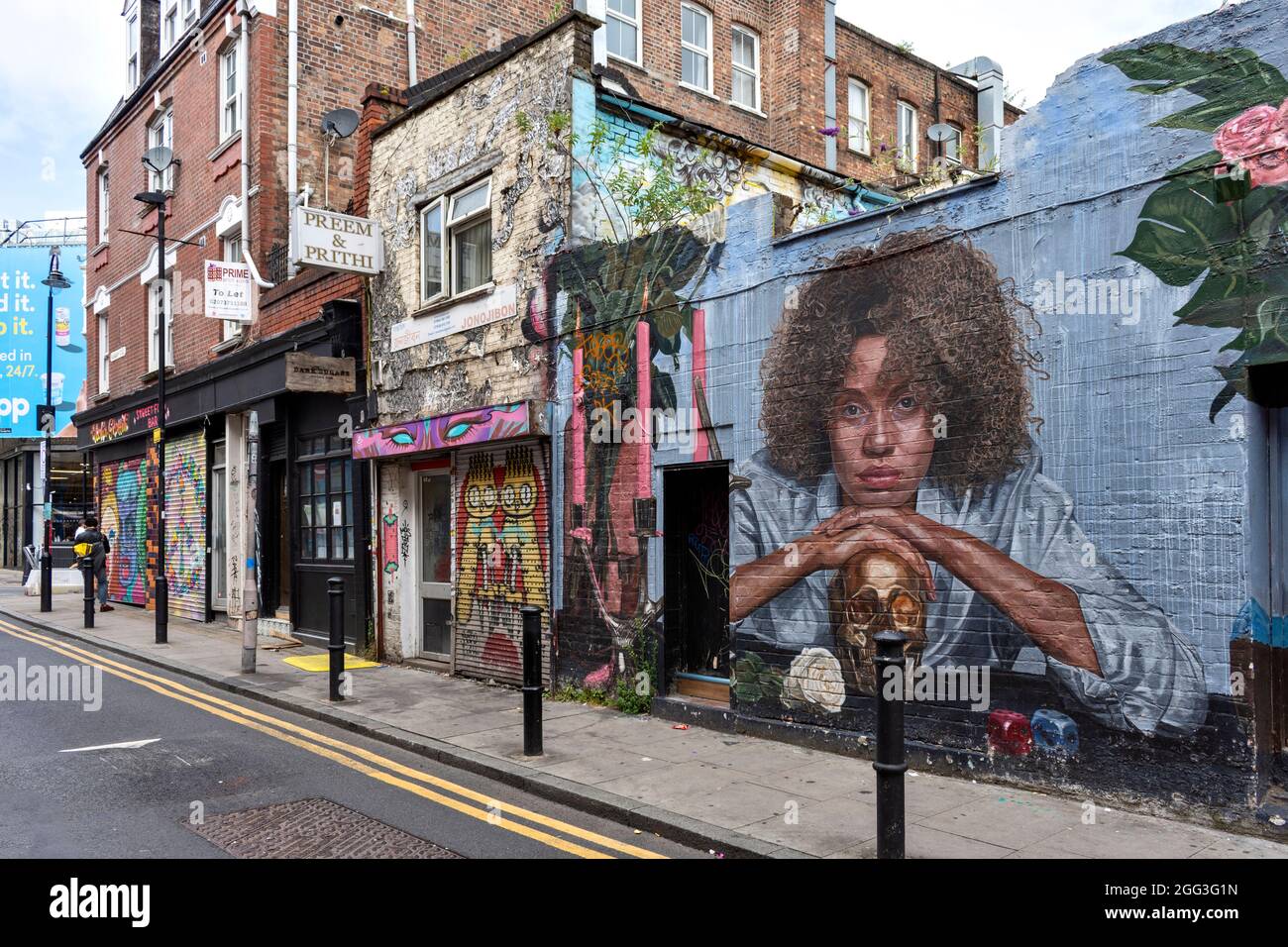 LONDON ARTISTIC AND CULTURAL AREA AROUND BRICK LANE WITH CREATIVE DESIGNS AND SLOGANS HANBURY STREET HOUSES AND WALLS Stock Photo