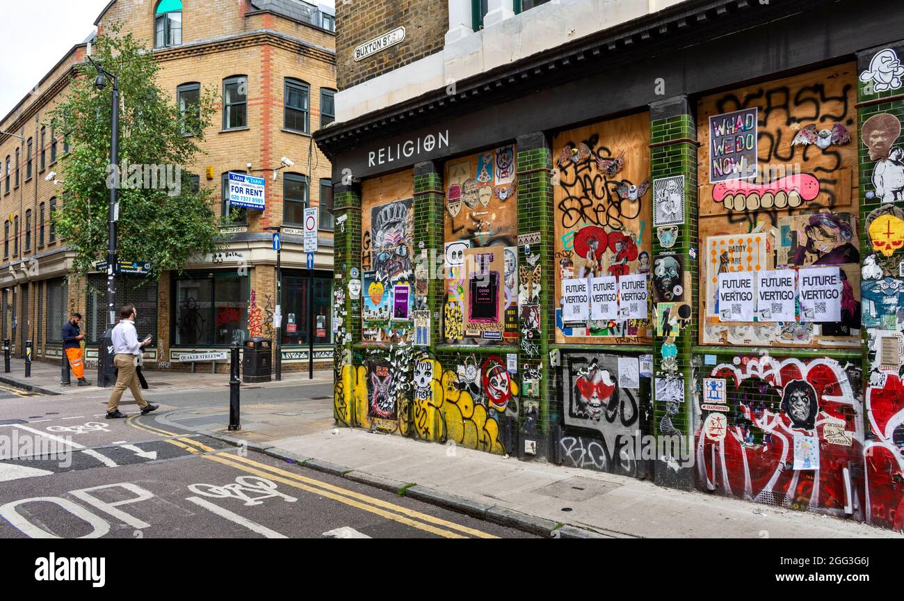 LONDON ARTISTIC AND CULTURAL AREA AROUND BRICK LANE WITH CREATIVE DESIGNS AND SLOGANS RELIGION IN BUXTON STREET Stock Photo