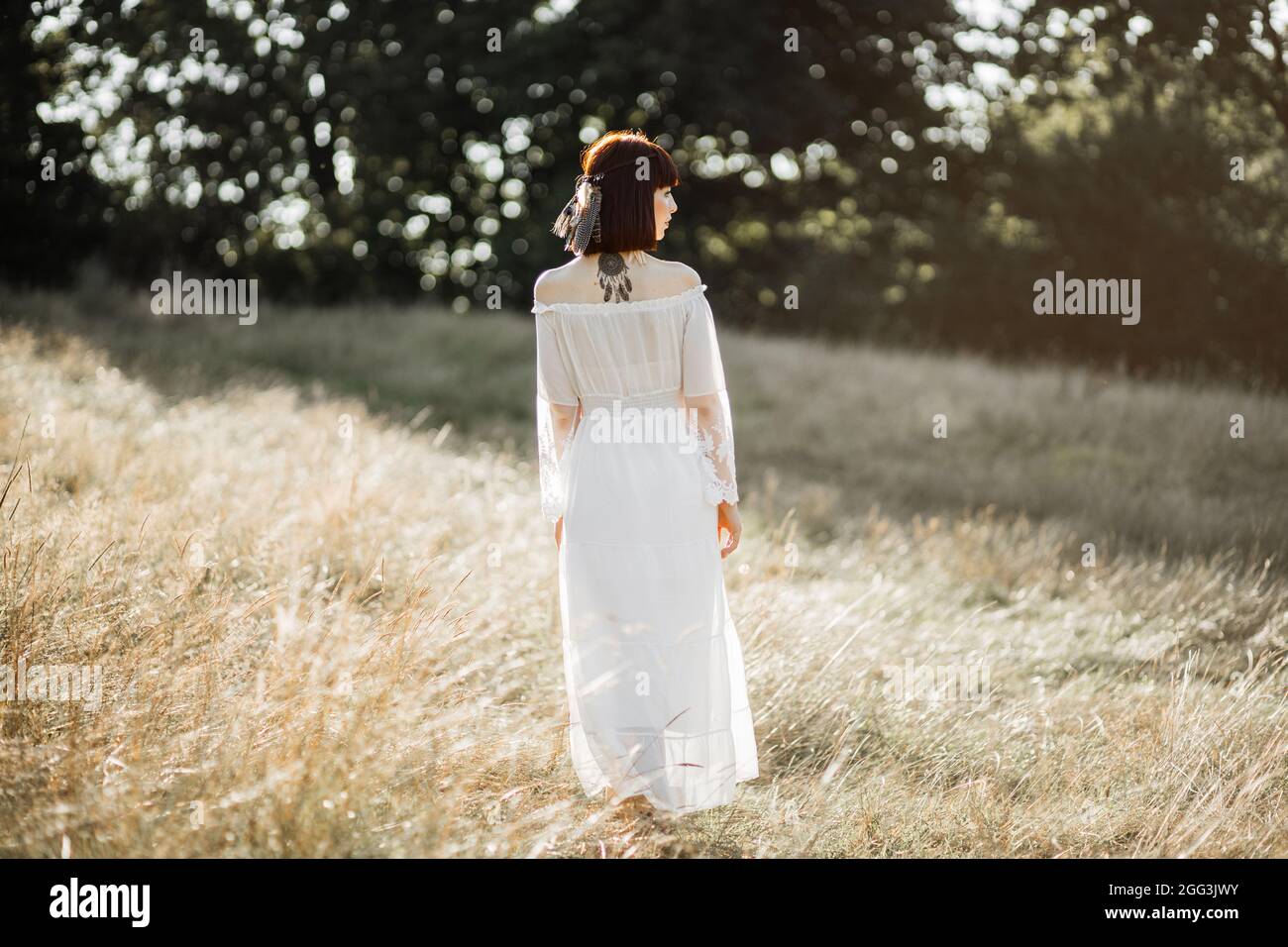 Beautiful tribal calm native american woman in white dress, standing on  background of sunset in the wild field, in harmony with nature Stock Photo  - Alamy
