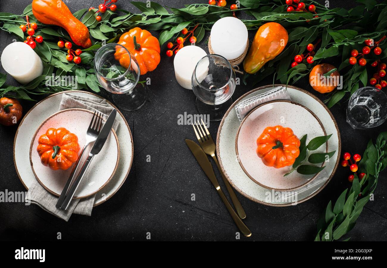Autumn table setting with plate, pumpkin and candles Stock Photo - Alamy