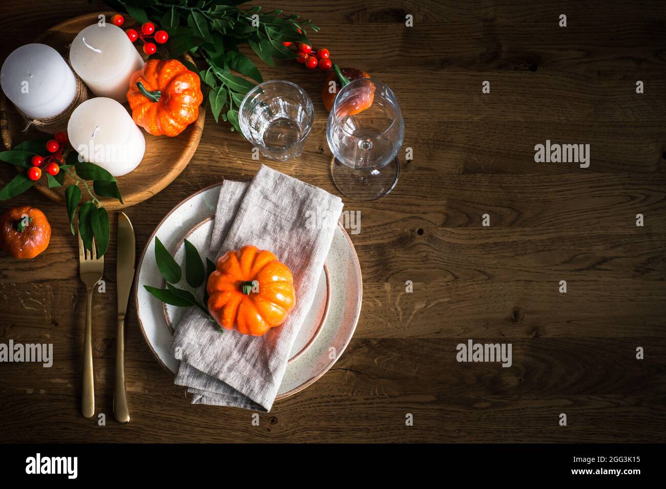 Autumn table setting with plate, pumpkin and candles Stock Photo - Alamy