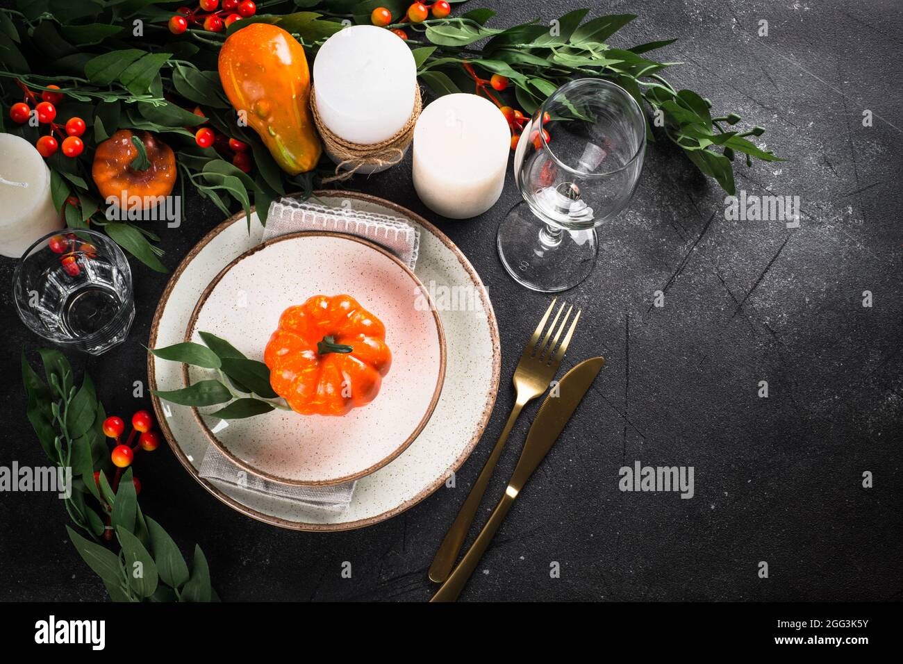 Autumn table setting with plate, pumpkin and candles Stock Photo - Alamy