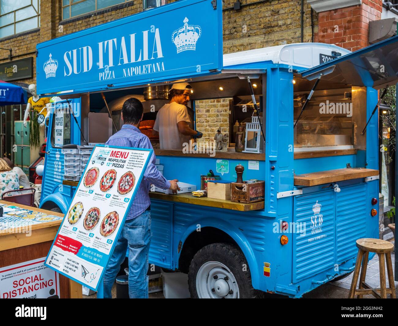 London Street Food Pizza - A mobile Pizza van fires up the oven in London's Spitalfields market ready for the lunchtime rush. Stock Photo