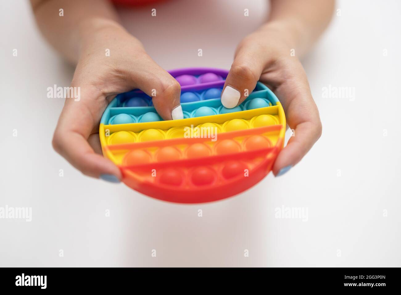 Pop it trendy kids fidget toy isolated on a white background. Rainbow  colored silicone sensory toy. Antistress gadget Stock Photo - Alamy