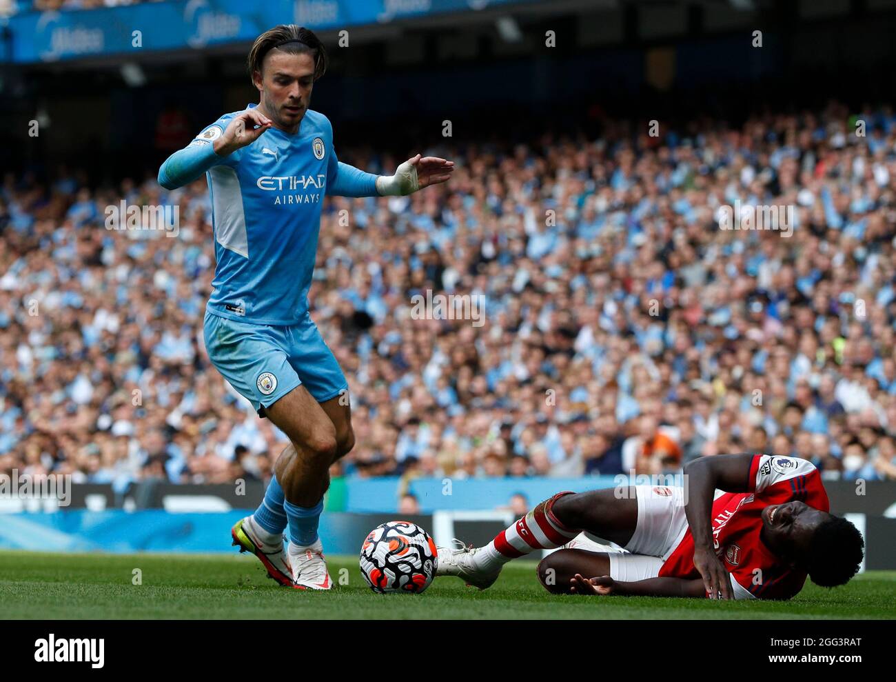 Manchester, England, 28th August 2021.  Jack Grealish of Manchester City challenges Bukayo Saka of Arsenal during the Premier League match at the Etihad Stadium, Manchester. Picture credit should read: Darren Staples / Sportimage Stock Photo