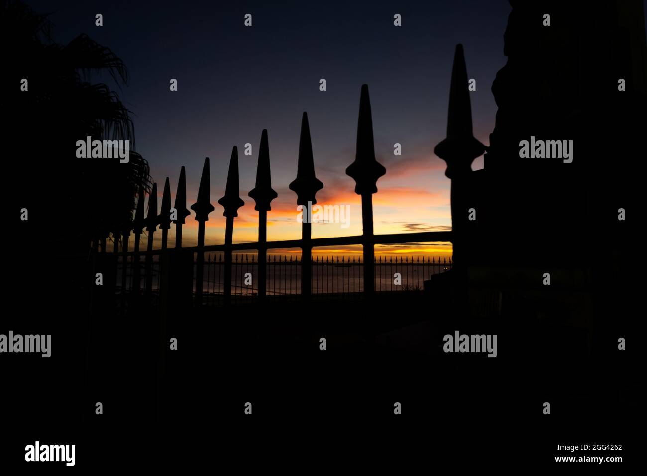 Salvador, Bahia, Brazil - June 11, 2021: Silhouette of railings with spears, trees and a lamp post in the Castro Alves square in Salvador, Bahia. Stock Photo