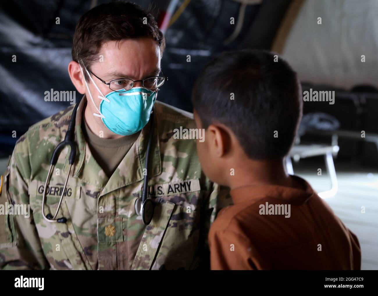 U.S. Army Maj. Philip Goering, a family medicine physician, U.S. Army Health Clinic Wiesbaden, Landstuhl Regional Medical Center, evaluates an Afghan evacuee seeking medical assistance as part of medical operations in support of Operation Allies Refuge at Ramstein Air Base, Germany, Aug. 26. The medical operations are part of U.S. Armed Forces medical efforts in response to the Afghanistan evacuations at Ramstein Air Base, which has transformed itself into the logistical hub for the evacuation of people from Afghanistan. Stock Photo