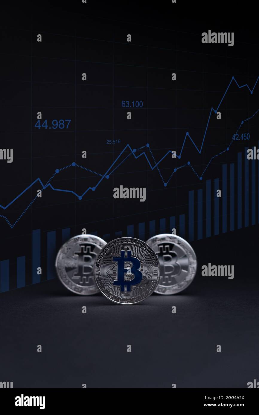 Silver Bitcoin coins currency. Crypto coin with growth chart, on a dark background. BTC International stock exchange. Stock Photo