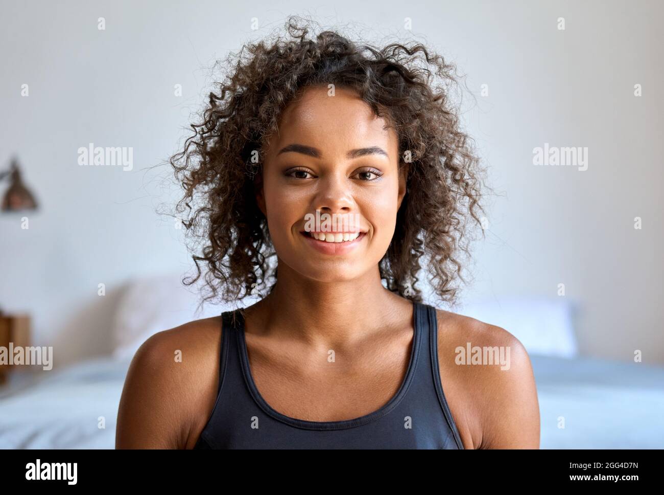 Headshot portrait of young mixed raced woman looking at camera indoors. Stock Photo