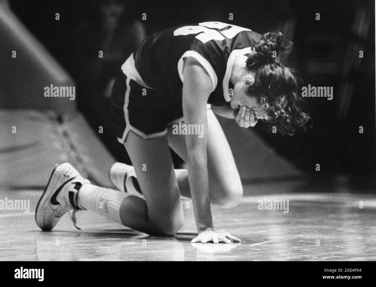 Austin Texas USA, circa 1988: Sports Injury: Teen girl reacts after being hit in the face during a high school basketball game. ©Bob Daemmrich Stock Photo