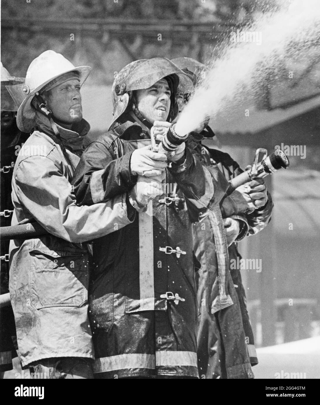 Texas Two Step Firefighting College Station Texas USA, 1978: Fire fighters wearing turnout gear ...