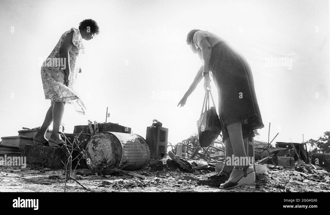 Circa 1984, two female congregation members look at the remains of their Central Texas church after it was destroyed by fire. ©Bob Daemmrich Stock Photo