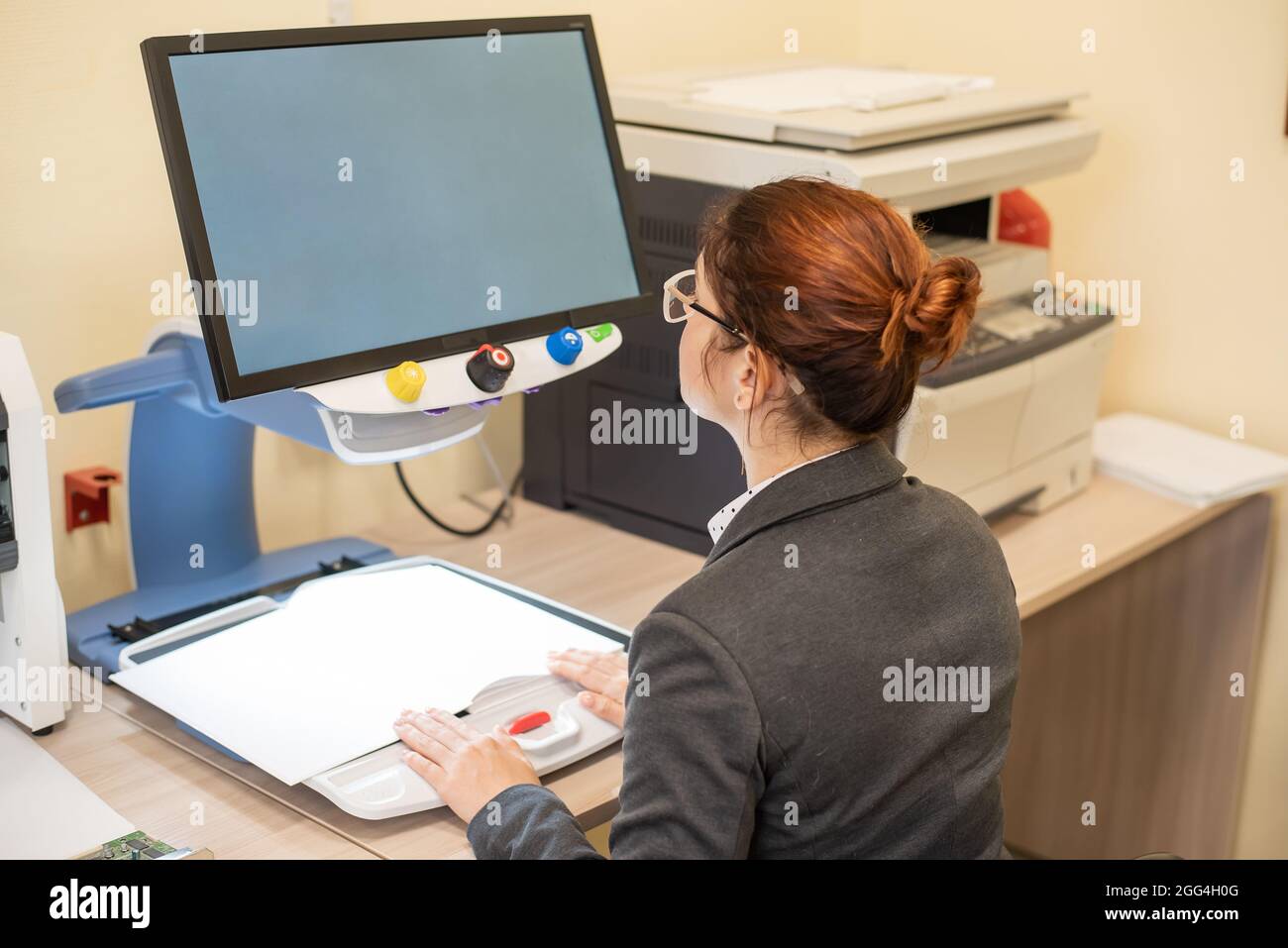 A visually impaired woman uses special reading equipment Stock Photo