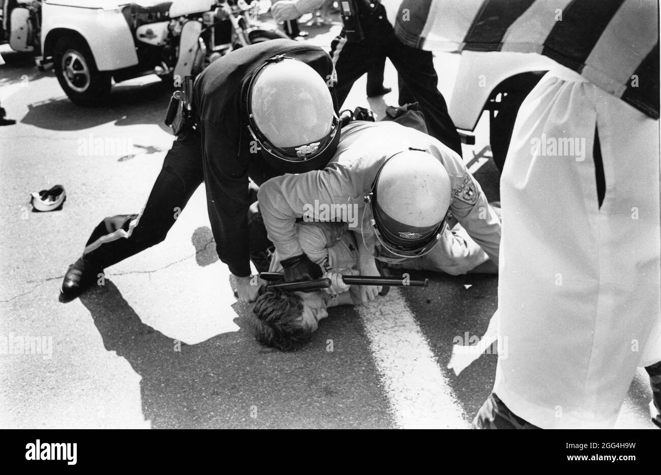 Austin Texas USA, 1983: Police use force to subdue protester as members of the Ku Klux Klan (KKK) rally at the Texas Capitol. Police arrested 13 people who were part of a large crowd protesting against the white-supremacy group's presence in downtown Austin. ©Bob Daemmrich Stock Photo