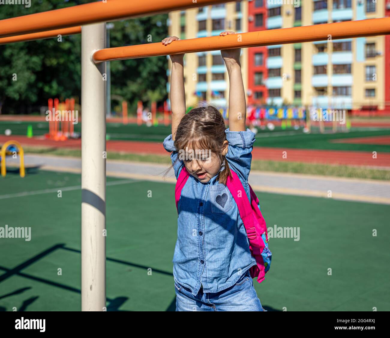 A little girl, an elementary school student, plays on the playground