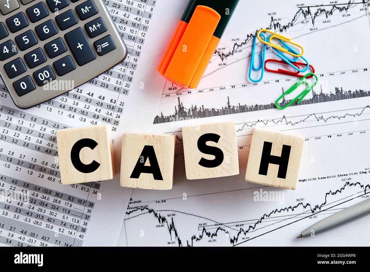 The word cash on wooden cubes with office desktop. Business, finance cash flow analysis concept. Stock Photo