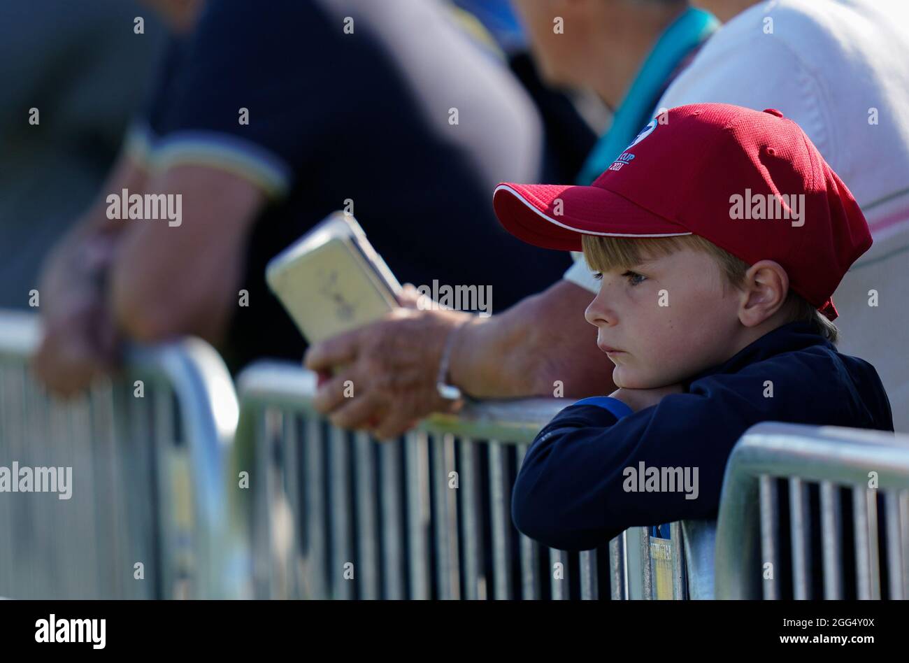 A young spectator watch the players warm up on the range during the 2021 Curtis Cup Day 3 - Singles at Conwy Golf Club, Conwy, Wales on Saturday, Aug. Stock Photo