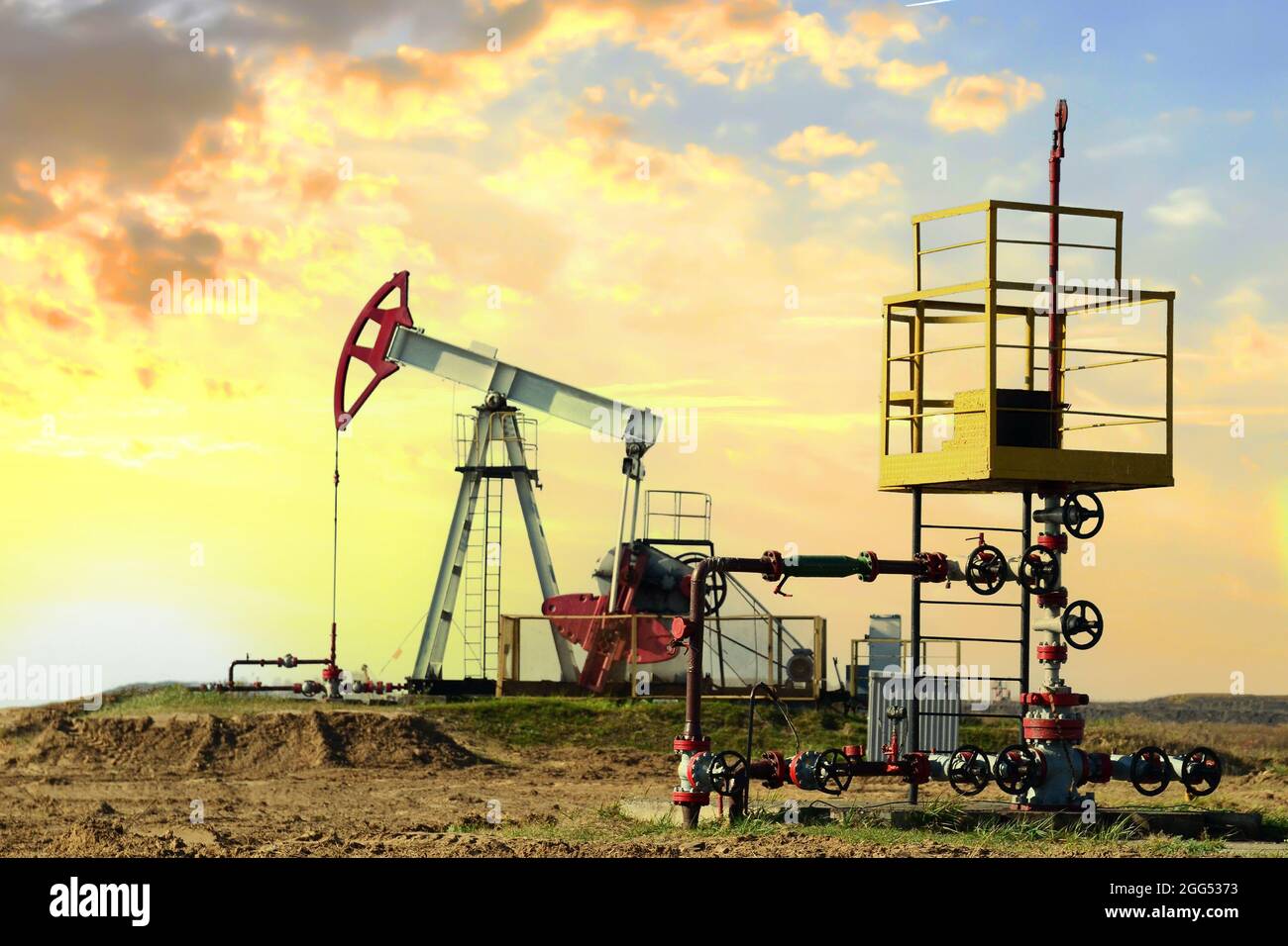 Crude oil pump jack at oilfield on sunset backround. Fossil crude