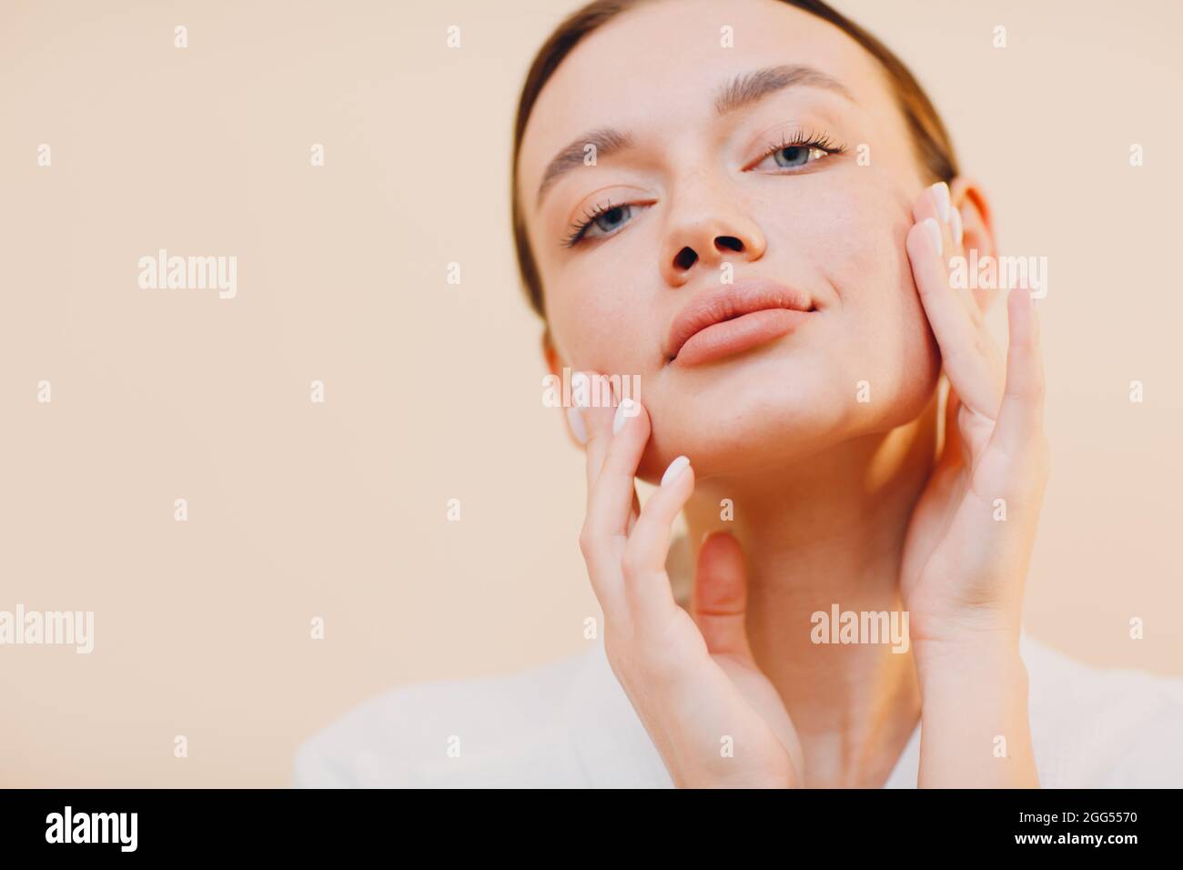 Young caucasian woman doing facebuilding yoga facial gymnastics self lymph facelift massage. Stock Photo