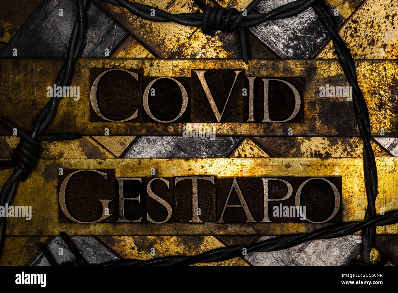 Covid Gestapo text on grunge copper and vintage gold background with barbed wire Stock Photo