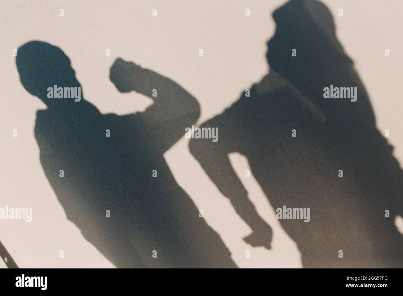 Elbow bumping safety greeting of two people shadow on wall of coronavirus COVID-19 pandemia. New normal. Stock Photo