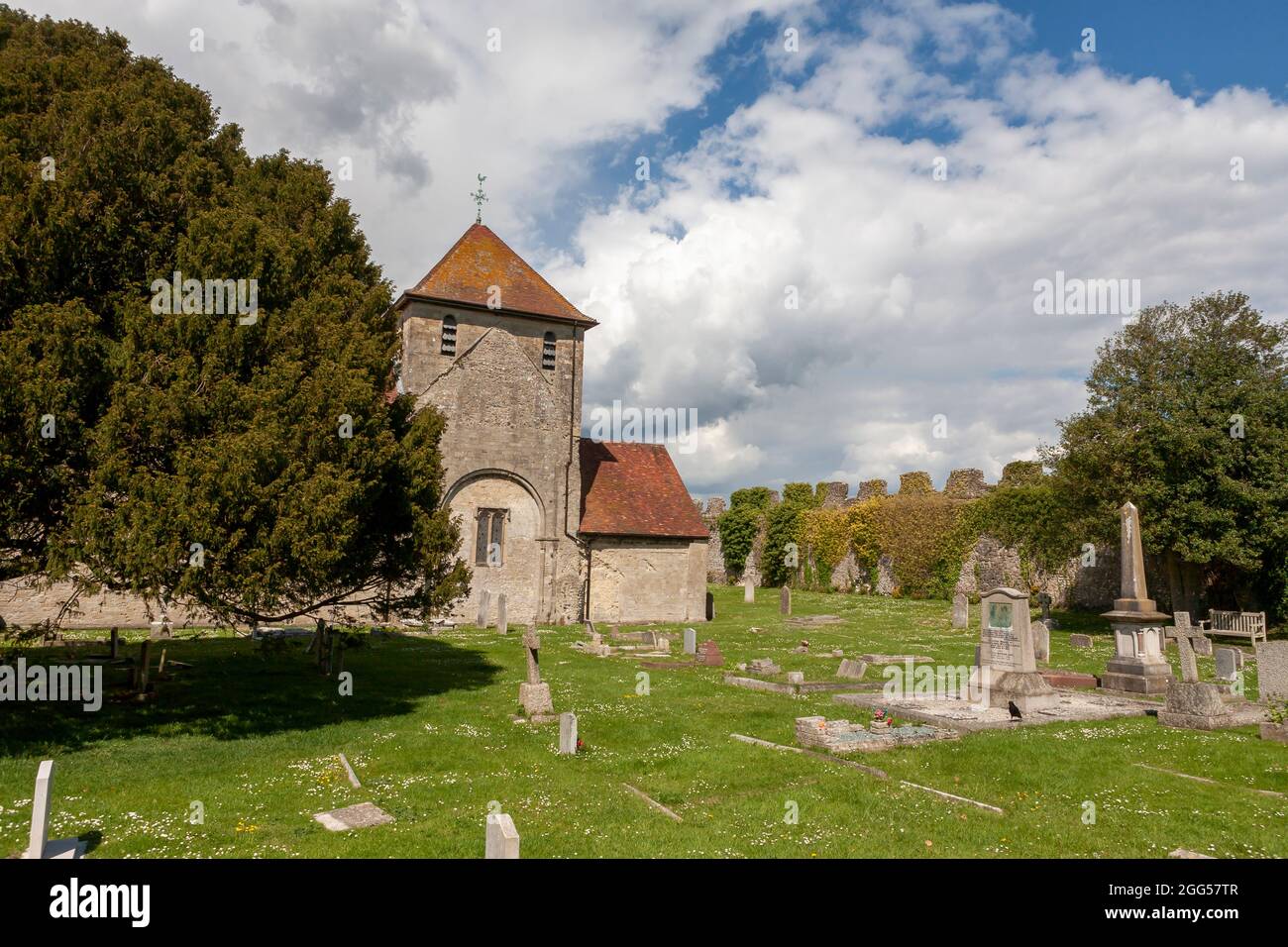 The 12th century church of St Mary, within Portchester Castle's outer bailey:cemetery and nearby walls of the original Roman fort, Hampshire, UK Stock Photo