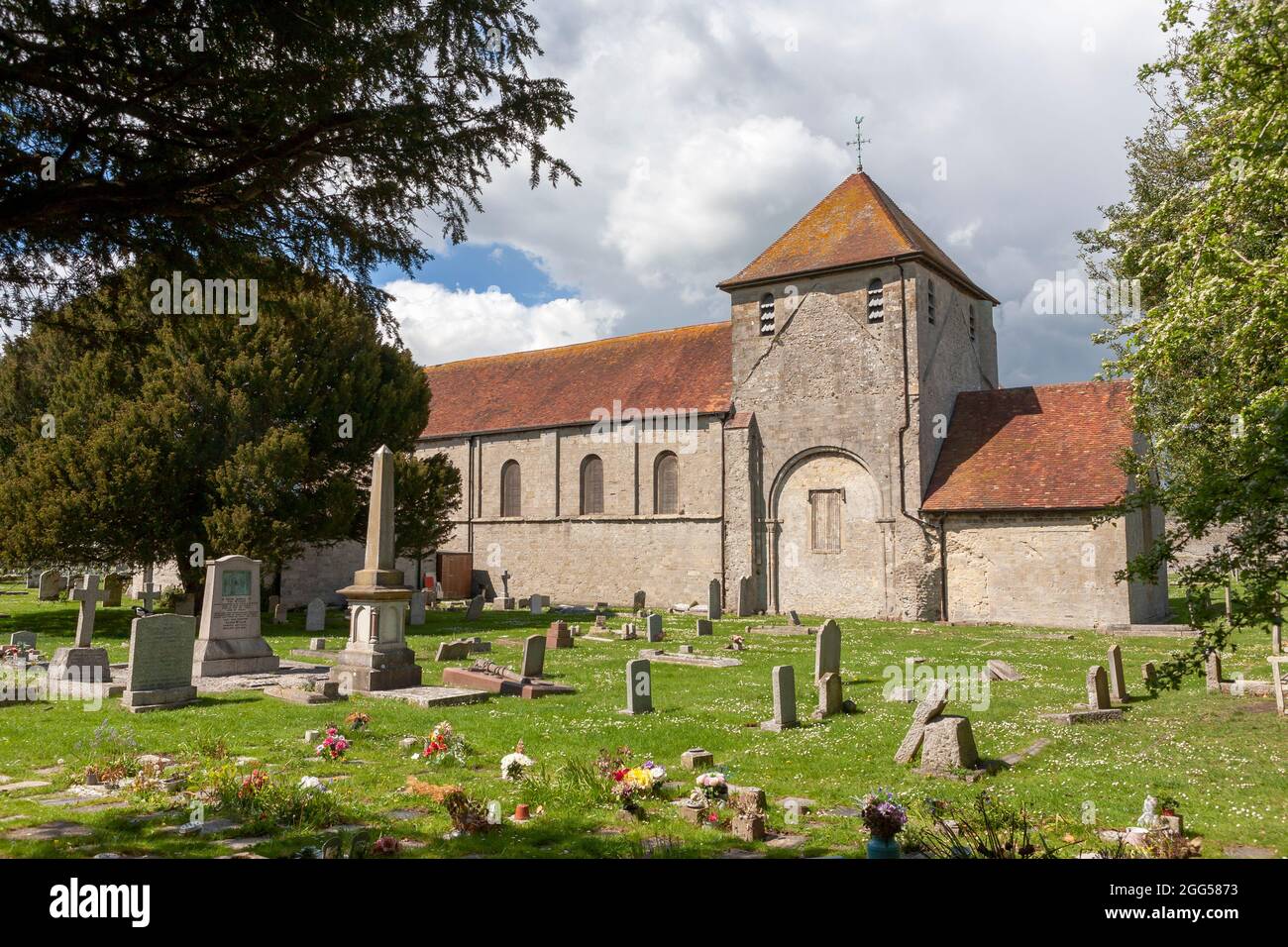 The 12th century Norman church of St Mary, within Portchester Castle's outer bailey, with the surrounding cemetery: Portchester, Hampshire, UK Stock Photo