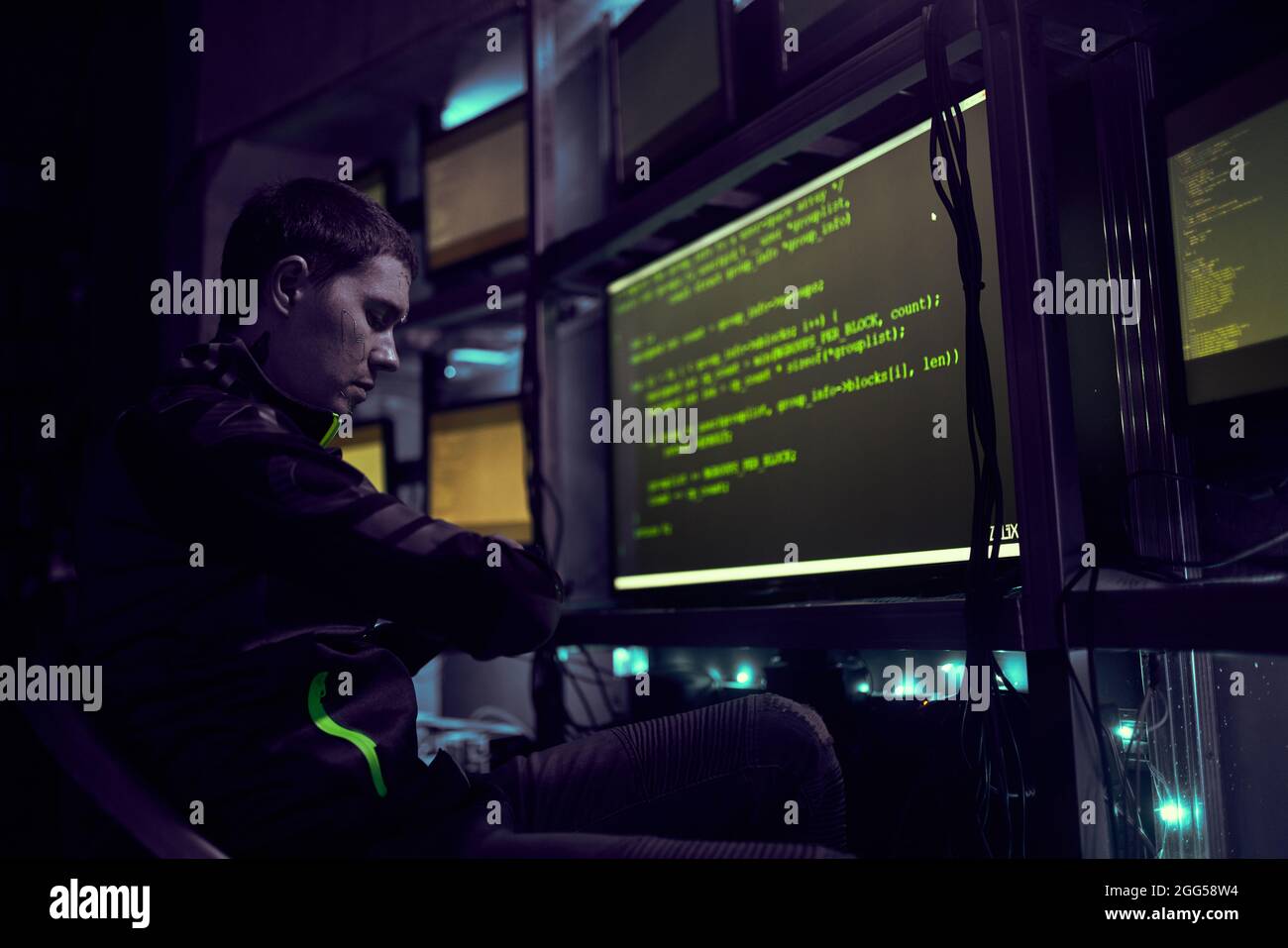 Hacker is working with computer typing text in dark room. Data security concept. Stock Photo