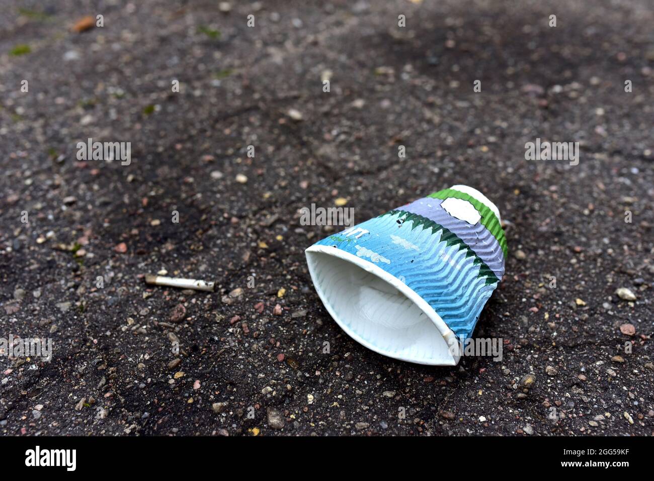 Crumpled a paper coffee cup on asphalt. Discarded disposable coffee cup ...