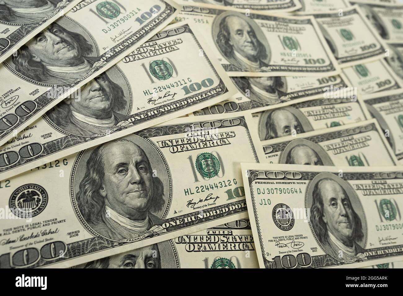 A money pile of one hundred US banknotes with president Franklin portrait. Cash of hundred dollar bills, paper currency background. Stock Photo