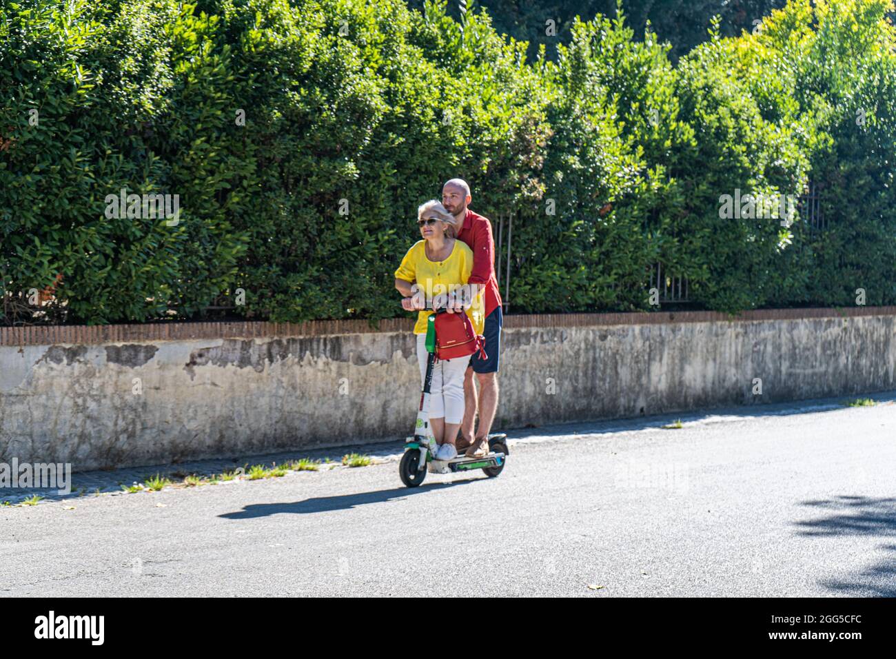 ROME ITALY, UK. 29th Aug, 2021. A man and woman riding together in Villa  Borghese on a Lime electric scooter on a hot day in Rome. Electric scooters  have become popular in