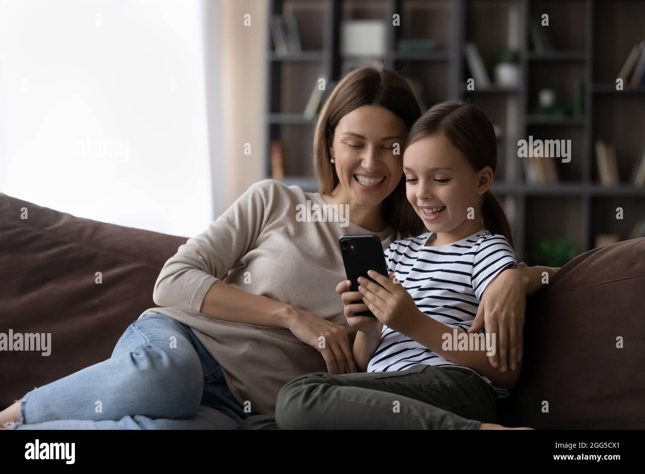 Happy mother and small daughter using cellphone Stock Photo - Alamy