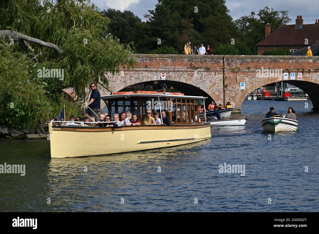 A sightseeing boat on the River Avon in Stratford upon Avon, Warwickshire approaches the jetty to disembark its passengers Stock Photo