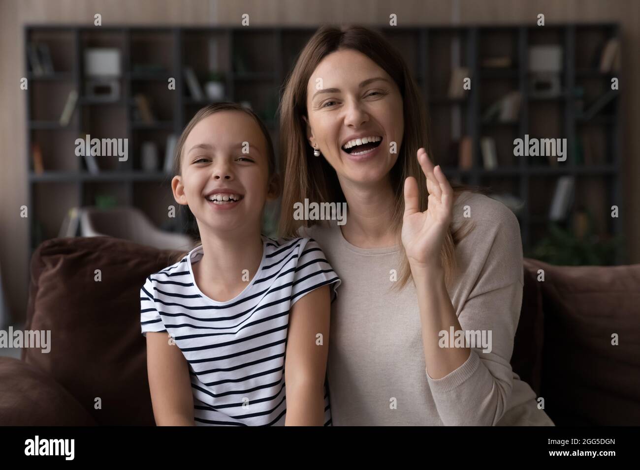 Happy young woman and small daughter holding video call Stock Photo - Alamy