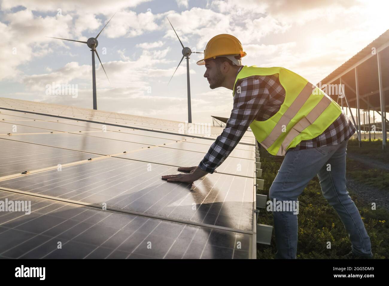 Man working for solar panels and wind turbines - Renewable energy concept - Focus on male worker hands Stock Photo