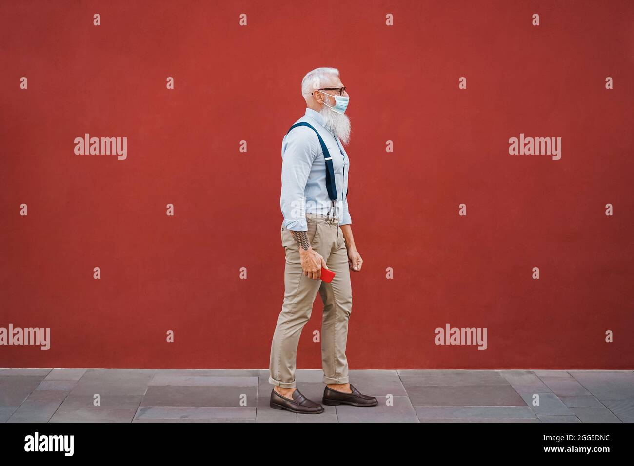 Hispter senior man walking around the city using safety mask - Focus on face Stock Photo