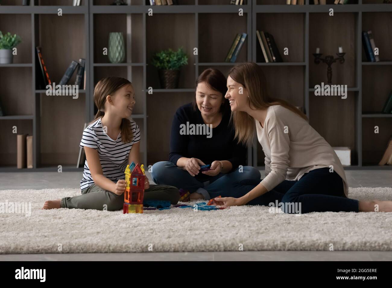 Happy three female generations family playing at home. Stock Photo